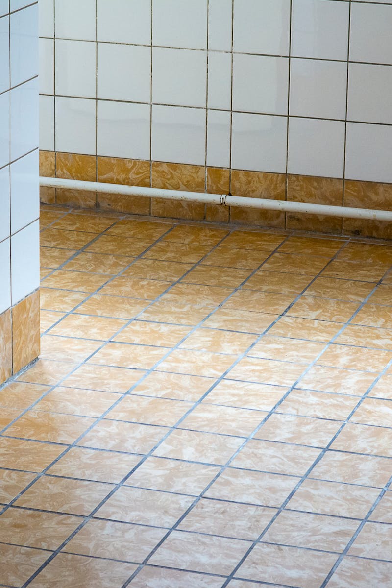 A clean, empty interior space with tiled flooring and walls, showcasing minimalist design.
